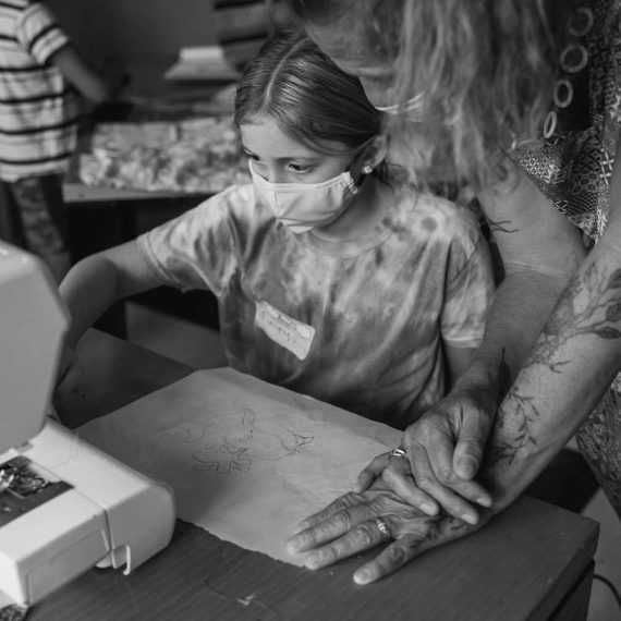 Young student being taught sewing